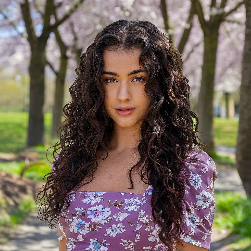 Long, voluminous curls with layered face-framing pieces for a naturally defined, bouncy hairstyle