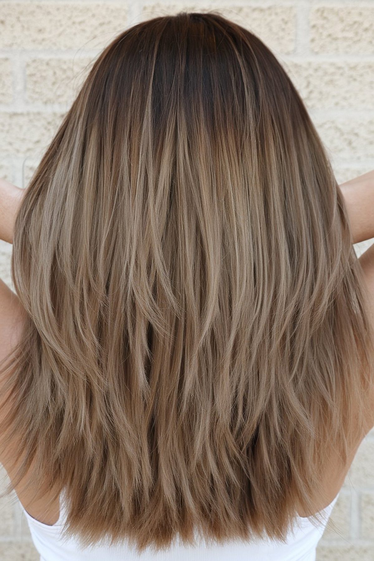 Medium-length layered haircut for thick hair with subtle ombré highlights